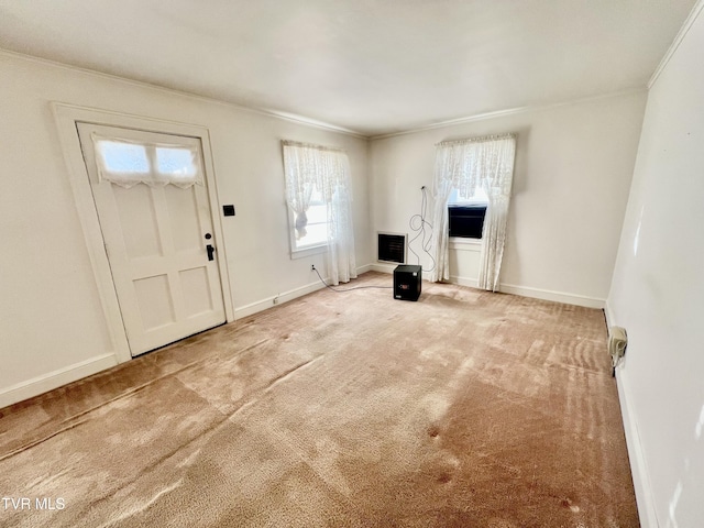 carpeted foyer with ornamental molding