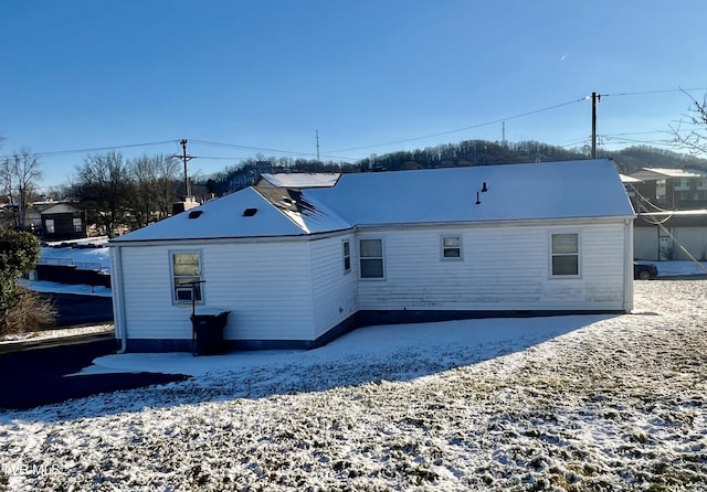 view of snow covered rear of property