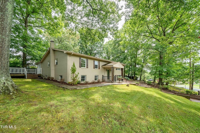 back of house with a lawn and a patio