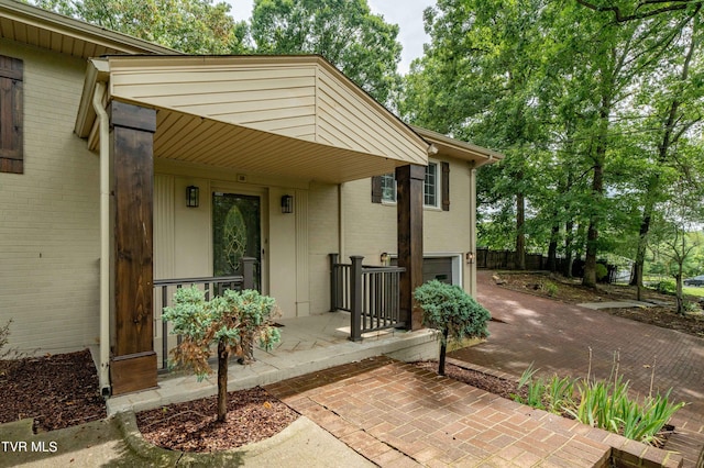 property entrance featuring a garage and a porch