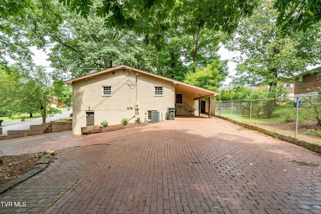 exterior space with central AC unit and a carport