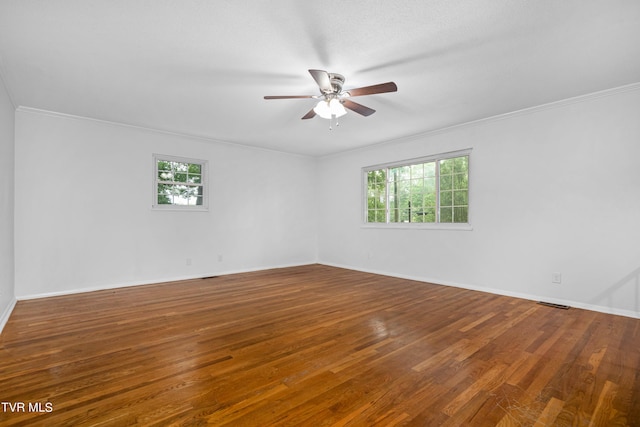 empty room featuring hardwood / wood-style flooring, ornamental molding, and ceiling fan