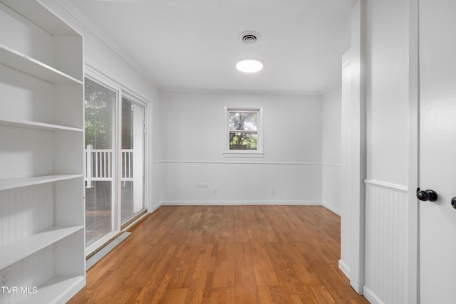 unfurnished room featuring ornamental molding and light hardwood / wood-style flooring