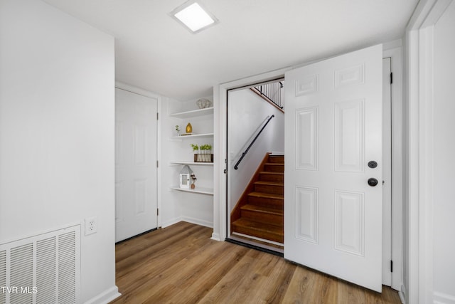 staircase with hardwood / wood-style flooring