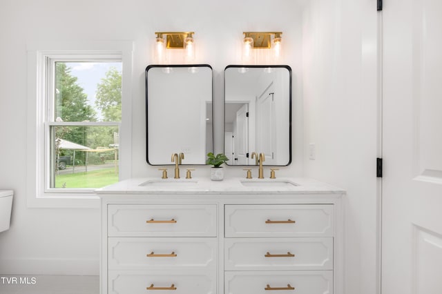 bathroom featuring double vanity, a sink, and a wealth of natural light