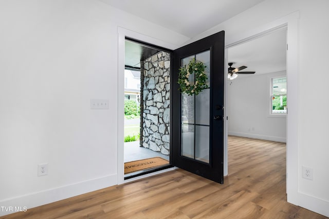 foyer featuring ceiling fan, baseboards, and wood finished floors