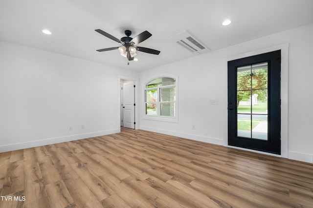 empty room with recessed lighting, light wood-style flooring, and baseboards