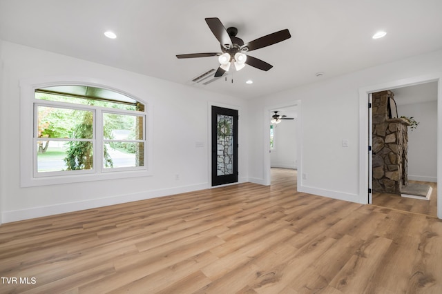 unfurnished living room with ceiling fan and light wood-type flooring