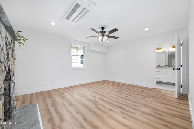 unfurnished bedroom featuring ceiling fan, connected bathroom, and light hardwood / wood-style flooring