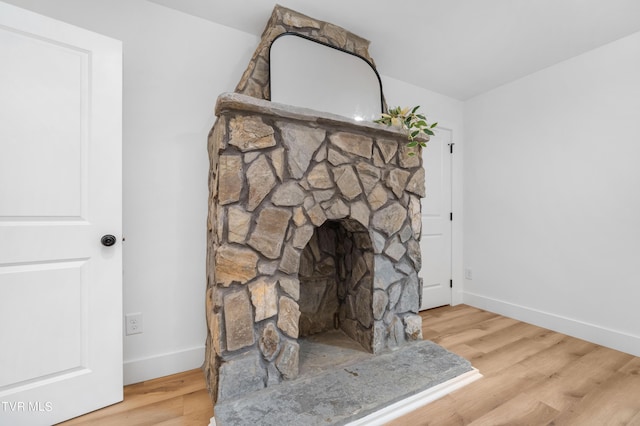 interior details with hardwood / wood-style flooring and a stone fireplace