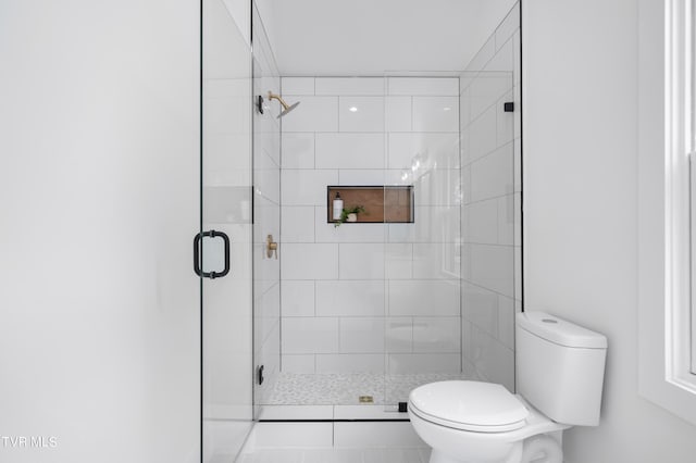 bathroom with toilet and an enclosed shower