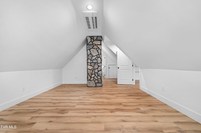 additional living space featuring baseboards, vaulted ceiling, and light wood finished floors