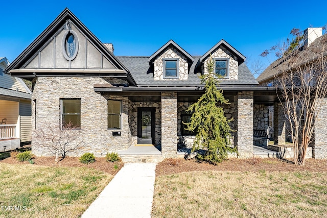 view of front of property featuring a front lawn and roof with shingles