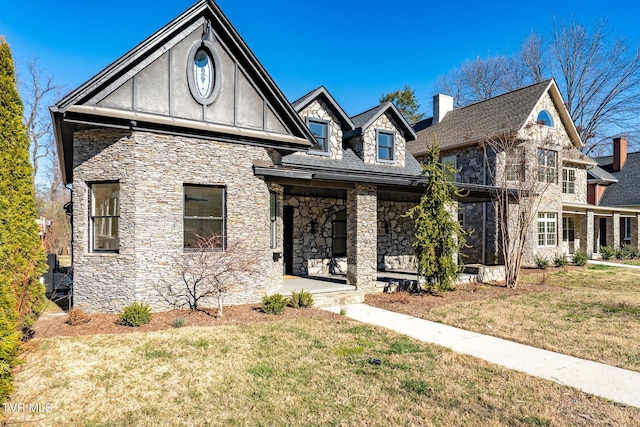 view of front facade with stone siding, a chimney, stucco siding, and a front yard