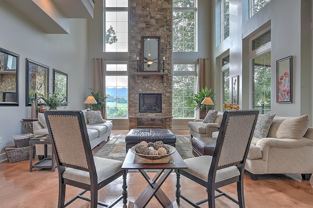 living room featuring a high ceiling and a stone fireplace