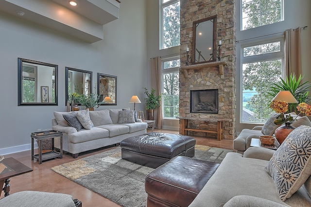 living room featuring a fireplace, a towering ceiling, and plenty of natural light