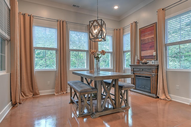 dining area with ornamental molding, a healthy amount of sunlight, and a chandelier