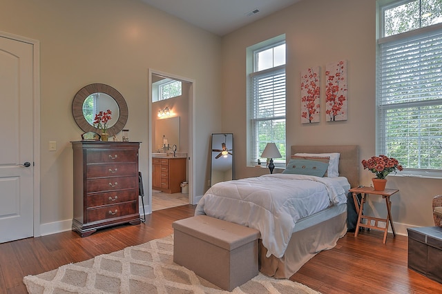 bedroom with ensuite bathroom and wood-type flooring