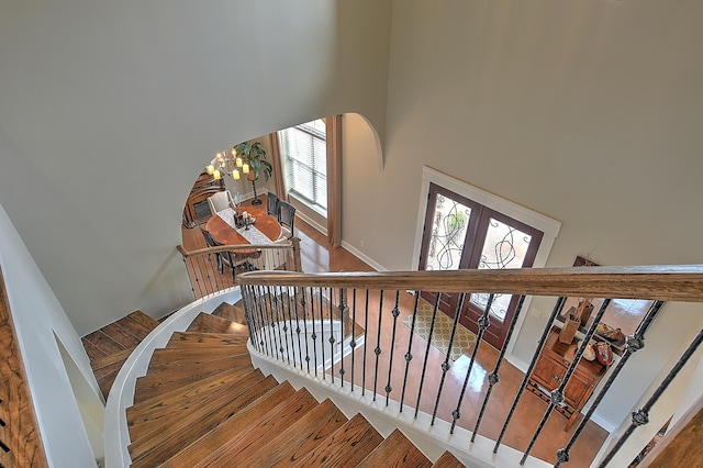 stairs with a high ceiling and a notable chandelier