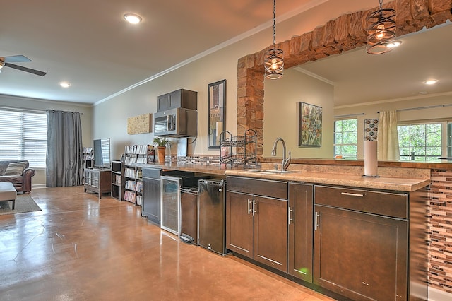 kitchen with decorative light fixtures, sink, decorative backsplash, and a healthy amount of sunlight