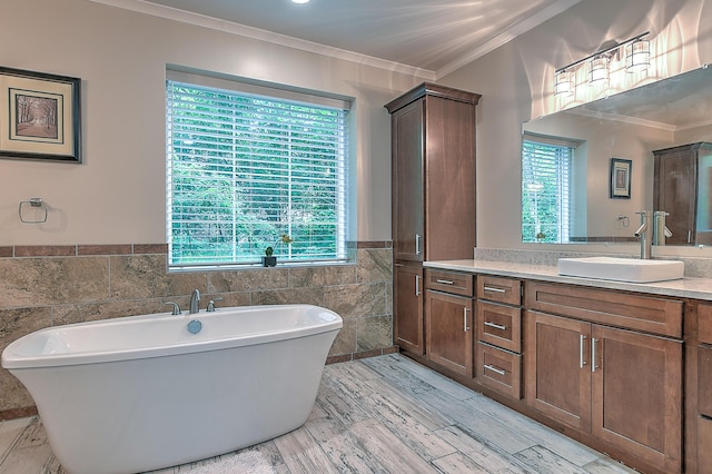 bathroom featuring a tub, tile walls, vanity, and ornamental molding