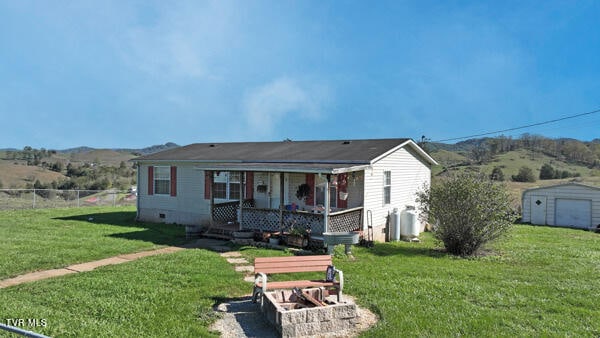 141 Pumplog Holw, Castlewood, VA 24224 - view of front of house featuring a mountain view, a front lawn, and a storage unit