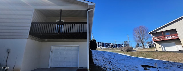 exterior space featuring a garage and a balcony