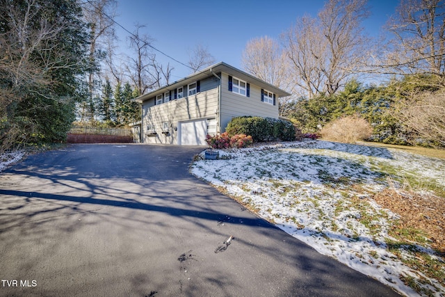 snow covered property with a garage