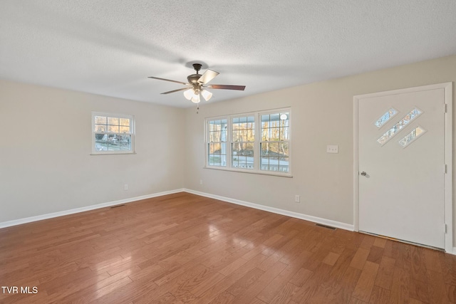 foyer featuring ceiling fan, wood-type flooring, plenty of natural light, and a textured ceiling