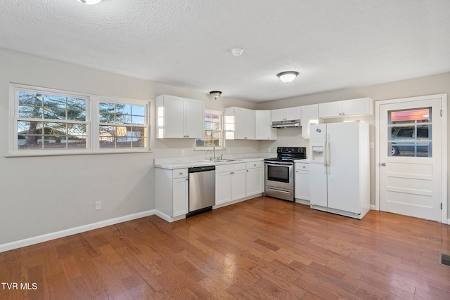 kitchen featuring appliances with stainless steel finishes, white cabinetry, and sink