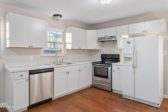 kitchen featuring stainless steel appliances, dark wood-type flooring, a textured ceiling, white cabinets, and sink