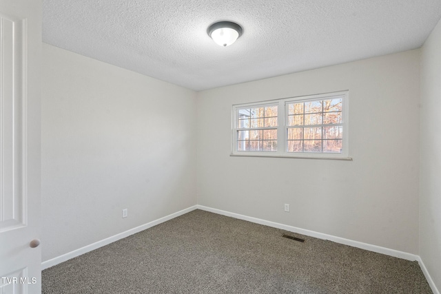 carpeted spare room with a textured ceiling