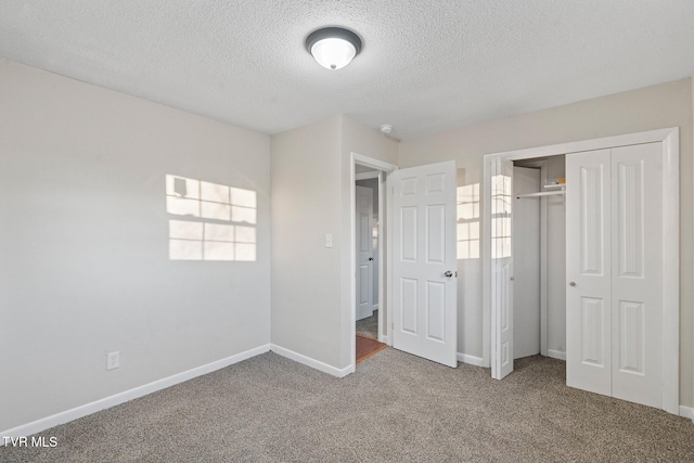 unfurnished bedroom with carpet, a closet, and a textured ceiling