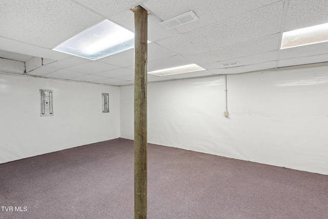 basement with a paneled ceiling, electric panel, and carpet floors