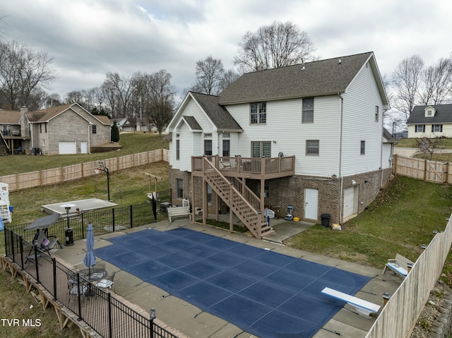 back of property with a swimming pool side deck, a patio, and a lawn