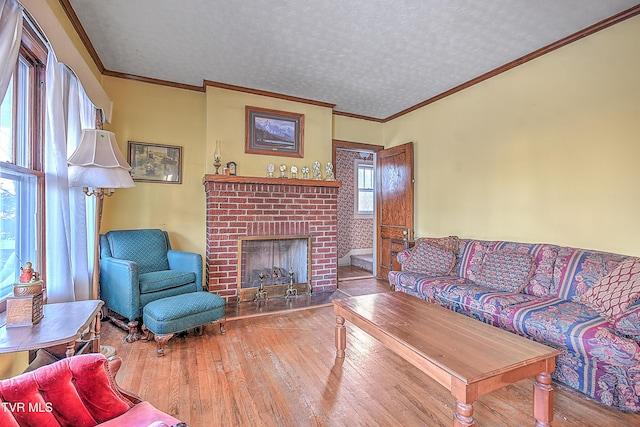 living room featuring a brick fireplace, a textured ceiling, and wood-type flooring