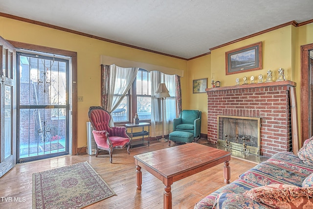 living room featuring a brick fireplace, a textured ceiling, light hardwood / wood-style flooring, and a wealth of natural light