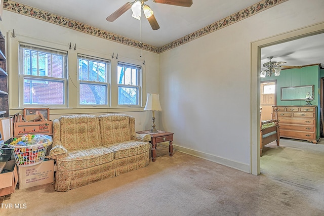 sitting room with ceiling fan and carpet