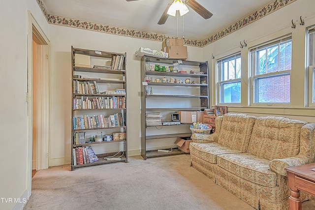 living area with ceiling fan and light colored carpet