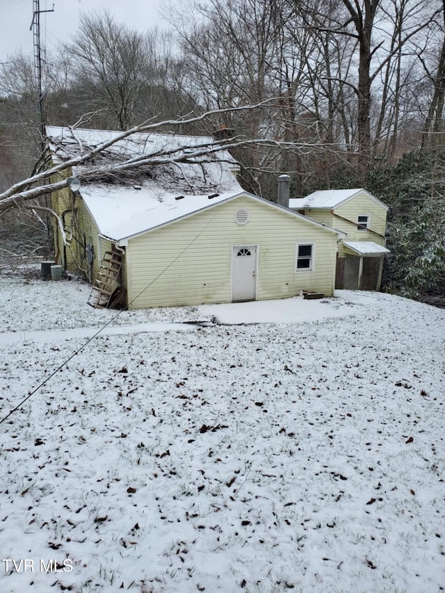 snow covered structure featuring central AC unit