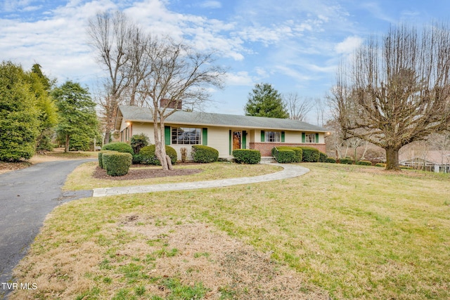 single story home with aphalt driveway and a front yard