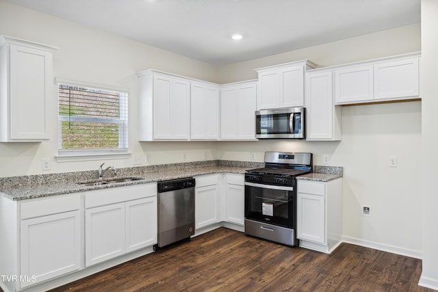 kitchen with light stone counters, sink, white cabinetry, and appliances with stainless steel finishes