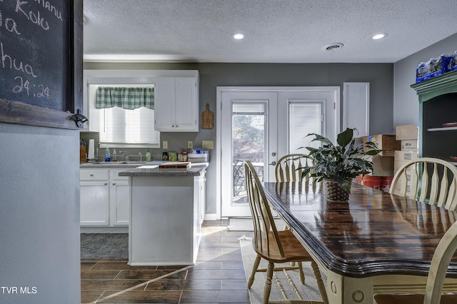 dining space featuring a wealth of natural light, french doors, and a textured ceiling