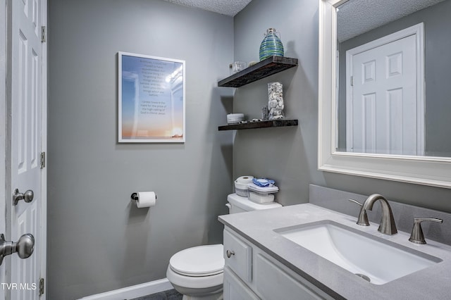 bathroom with vanity, a textured ceiling, and toilet