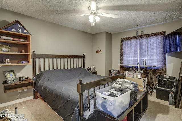 bedroom with ceiling fan, carpet floors, and a textured ceiling