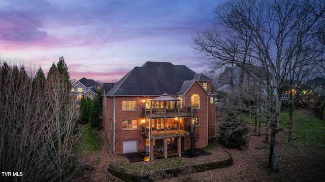 back house at dusk featuring a gazebo and a garage