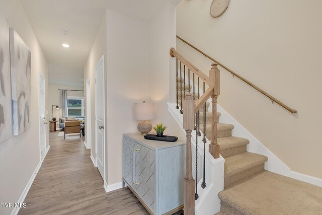 staircase featuring recessed lighting, baseboards, and wood finished floors