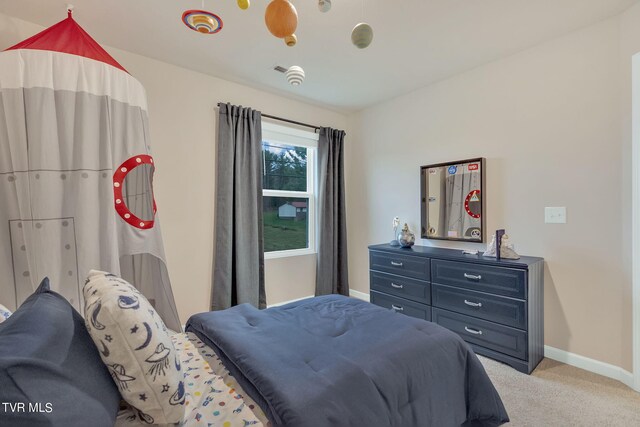 bedroom with light colored carpet and baseboards