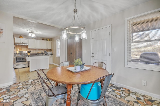 dining area featuring light tile patterned flooring and a textured ceiling