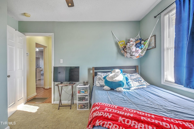 bedroom featuring ceiling fan, carpet floors, and a textured ceiling